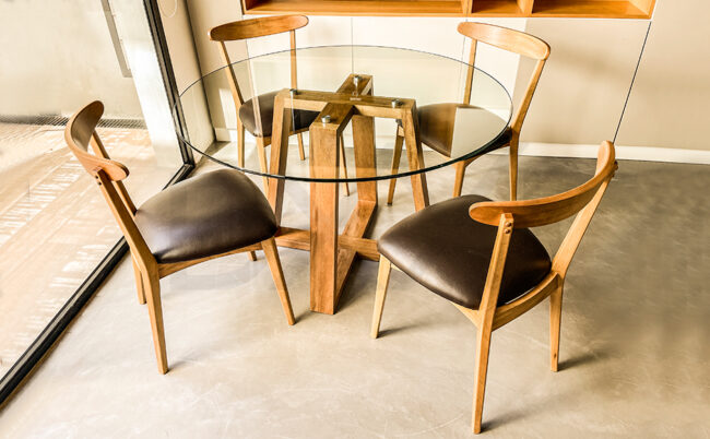 Mesa de comedor redonda con base de madera y tapa de vidrio modelo Lunar. DXXI - Fábrica de muebles a medida.